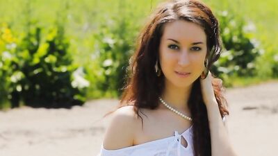 Nature loving girl wearing heels poses in a grassy summer field