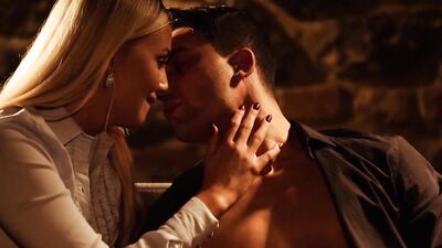 Stylish couple stages their sexual and erotic foreplay in a room with a low lite