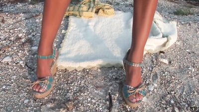 Skinny blonde with fake boobs is masturbating on the beach