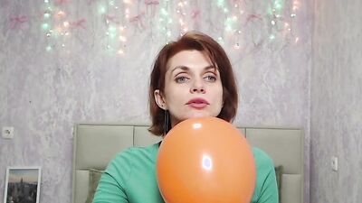 Redhead Milf plays with balloon on webcam