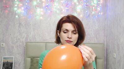 Redhead Milf plays with balloon on webcam