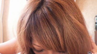 Her big eyes are emphasized while the beautiful asian babe sucks and swallows delicious cum