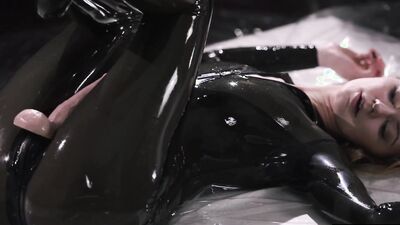 Kinky girl in black latex strokes her strapon until it squirts