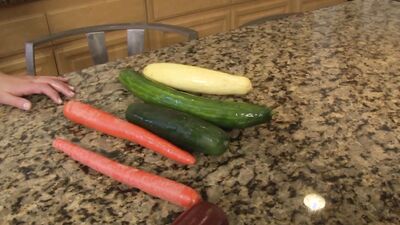 MILF washes a cucumber and ends up masturbating with it before using other veggies