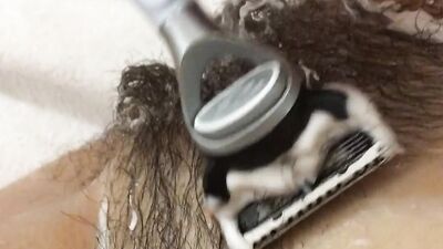 Girl shaves very hairy pussy. Shaving the pubis and anus close-up. Wet Lush Bush