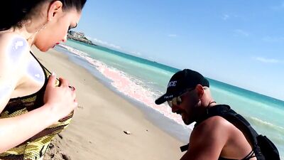 Hot MILF with big tits gets a helping hand from a police officer on the beach