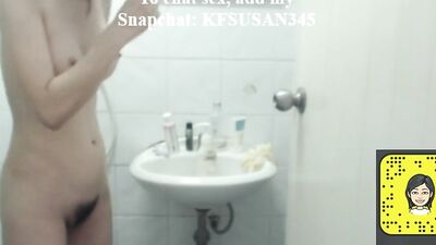 Woman is filming herself while being naked in a bathroom and putting on a lotion