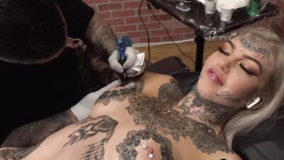 Tattooed harlot has her pussy stuffed with a dildo while rubbing her clit