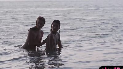 Two alluring girls are posing naked outdoors at a beach