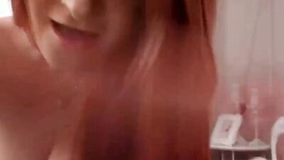 Curvaceous redhead chick is all alone while playing with a big white dildo